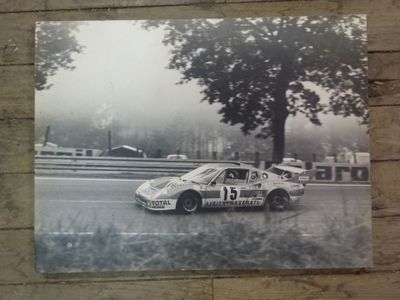 a black and white photo of a race car on the track