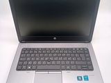 a silver laptop with a black keyboard on a white table