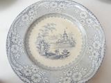 a blue and white plate with a picture of a town on it