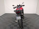 a red motorcycle parked in a room with a checkered floor