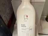 un flacon de lait corporel posé sur une boîte