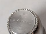 a close up of a silver container on a white surface