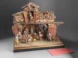 figurine of a nativity scene with a manger and a woman in a stable