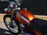 an orange motorcycle parked on the side of the road