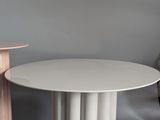 two tables and a lamp in a room with a gray wall