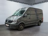 La camionnette grise est garée dans une grande pièce aux murs blancs.
