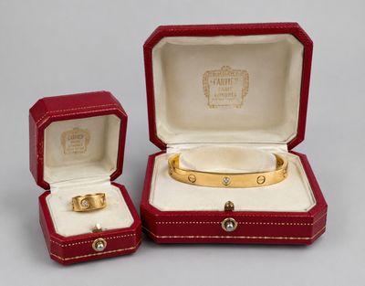 an image of a couple of red boxes with a gold bracelet