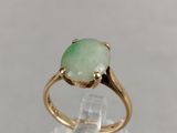 an image of a gold ring with a green stone on it