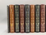 six livres sont alignés sur une surface blanche
