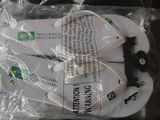 a pair of white flip flops in a plastic bag