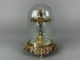 un dôme en verre renfermant une croix en or