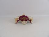 a small red and gold carriage with gold trimmings on it