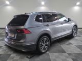 the rear end of a silver volkswagen suv parked on a checkered floor