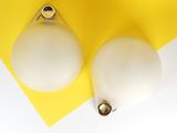 yellow and white background with two white lamps on top of a yellow and white surface