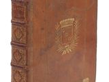 un vieux livre relié en cuir, orné de dorures et d'un blason sur la couverture