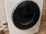 a white washing machine sitting on the floor next to a box