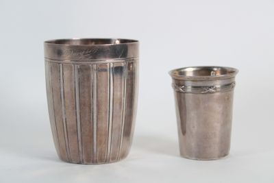 une coupe en argent à côté d'une autre coupe en argent sur une table