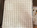 un tas de carreaux par terre, à côté d'une boîte de papier toilette