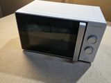 a white microwave sitting on a counter top next to a window