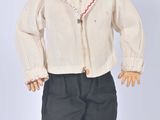 a small doll that is wearing a white shirt and black pants