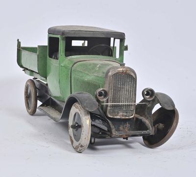 a green toy truck that is sitting on a white surface