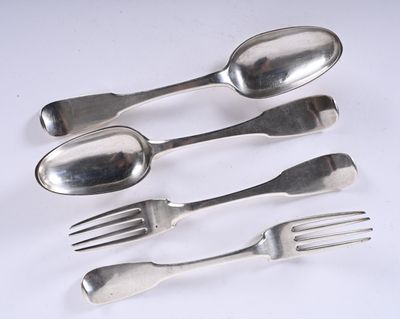 trois fourchettes, une cuillère et une fourchette posées sur une surface blanche