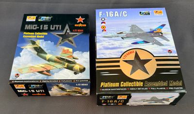 deux boîtes contenant des maquettes d'avions militaires posées sur une table
