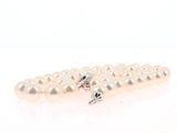 three white pearls are arranged in a row on a white surface