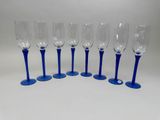 six blue wine glasses lined up on top of each other