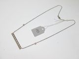 collier en métal argenté avec une étiquette de prix accrochée à sa chaîne
