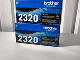 two brother black toner cartridges sitting on top of a white table
