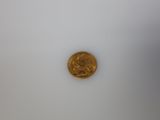 a gold coin sitting on top of a white surface