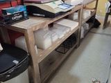 a desk with a laptop and a trash can in the corner