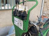 a green machine that is sitting outside of a building