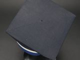 a blue graduation cap on top of a black table