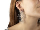 woman wearing a black and white dress and silver earrings