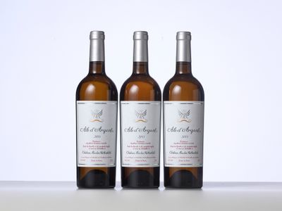 trois bouteilles de vin posées sur une table l'une à côté de l'autre