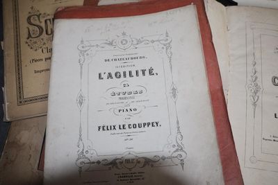 un livre posé sur une table, à côté d'une pile de livres