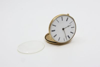 une bague en or surmontée d'une horloge blanche