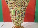 a vase on a table with a red wall in the background