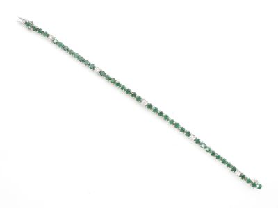 un gros plan d'un bracelet vert et blanc posé sur une surface blanche