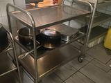 un chariot métallique sur lequel sont posés des casseroles et des poêles, dans une cuisine