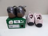 two pairs of baby shoes sitting on a table
