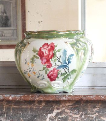 un vase posé sur le rebord d'une fenêtre, avec une photo en arrière-plan