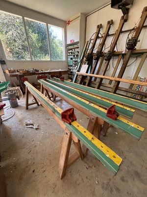 Dans un atelier, plusieurs morceaux de bois sont empilés les uns sur les autres