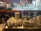 a lot of dishes and cups on the counter