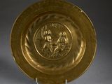 assiette en or décorée d'un motif représentant un homme et une femme