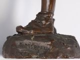 bronze statue of a person ' s foot on a rock with writing on it