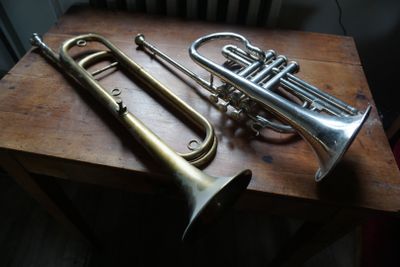 deux trompettes posées sur une table en bois près d'un radiateur