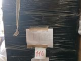 un grand réfrigérateur noir au milieu d'une pile de cartons